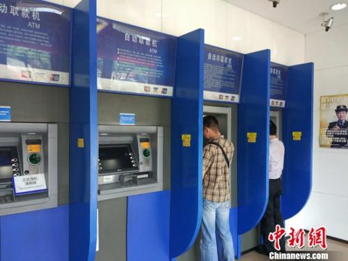民眾在自動取款機上取款。<a target='_blank'  _fcksavedurl='http://www.chinanews.com/' ></table><p align=